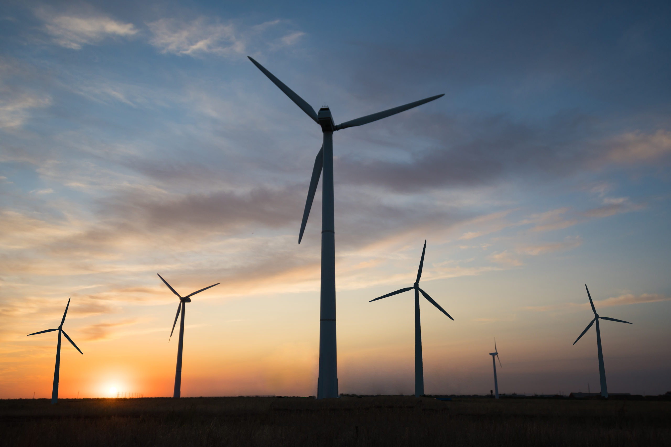 Power generators of windmills at sunset of the day